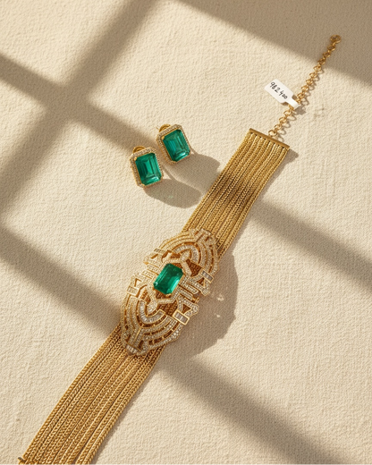 Gold necklace with green gemstones on a beige surface