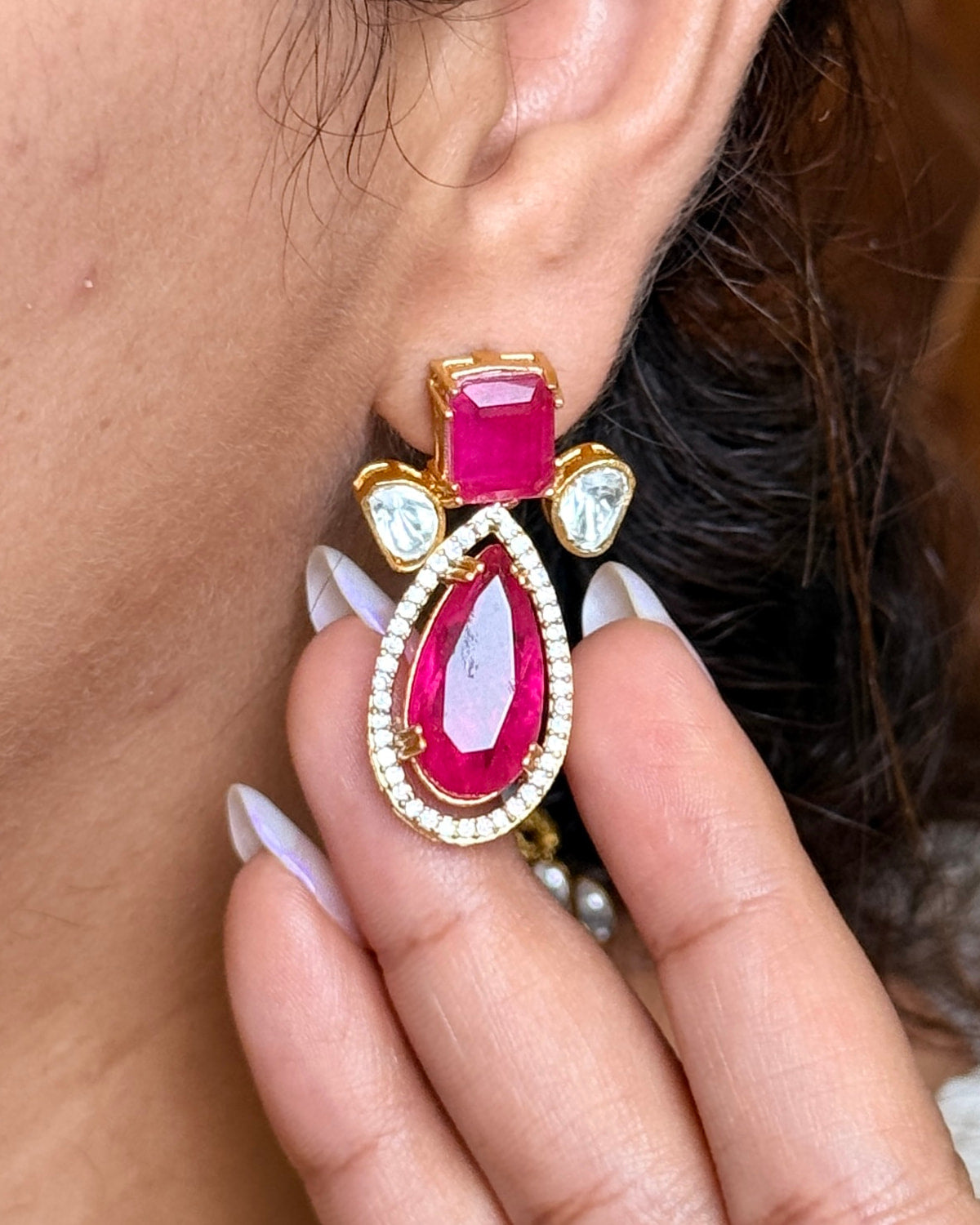Earring with pink gemstone worn by a person