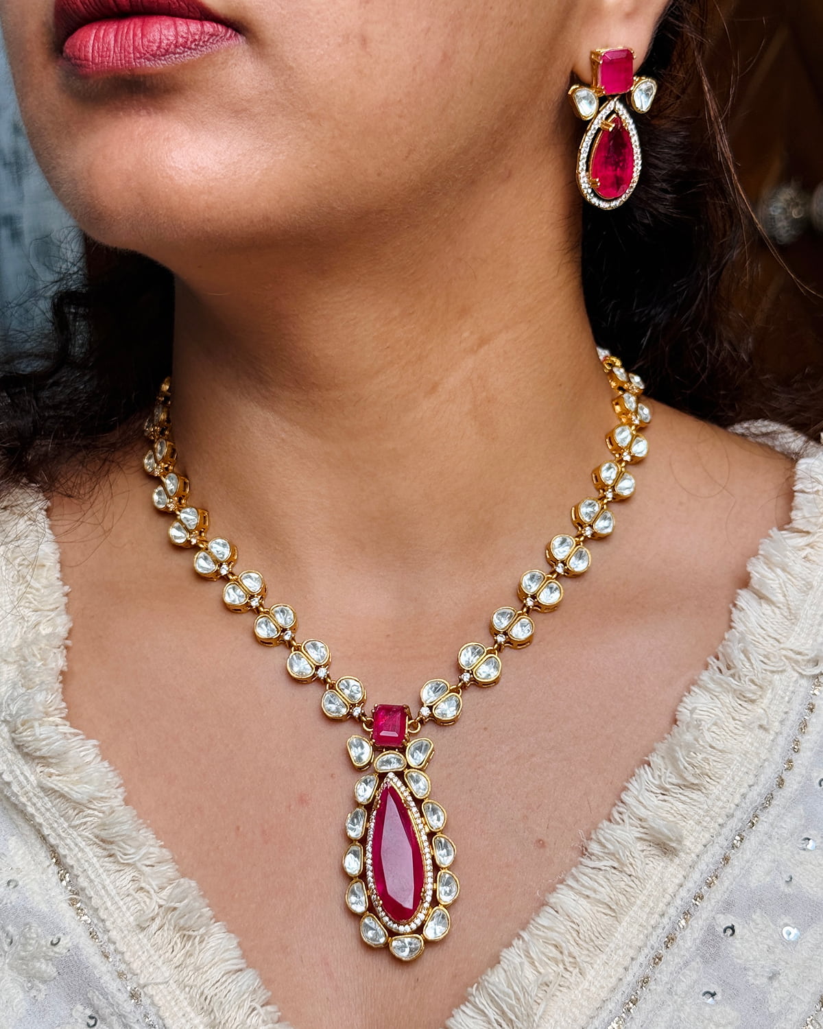 Woman wearing a necklace and earrings with red gemstones
